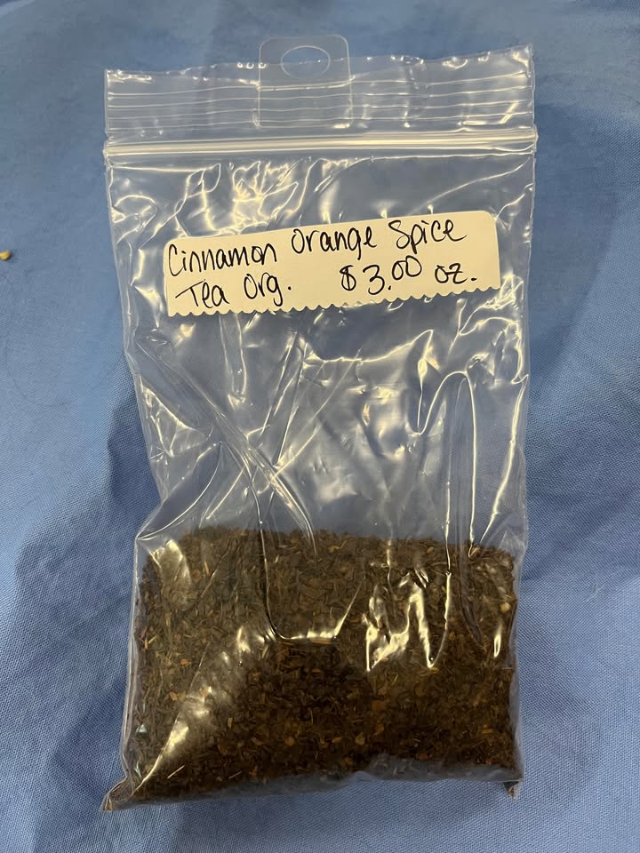 Coffee-colored leaves in plastic zip package, with label saying "Cinnamon Orange Spice Tea (Organic), $3 per oz."