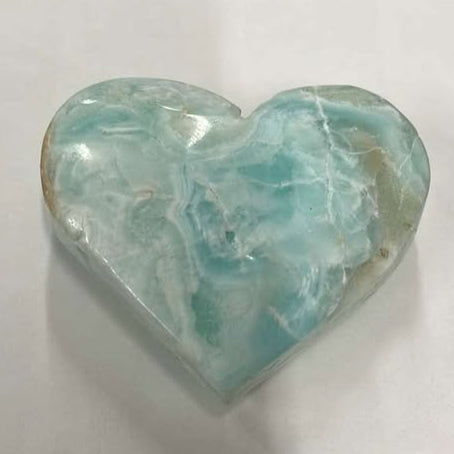 Turquoise crystal heart with white, gray, and brown marbled into the stone.