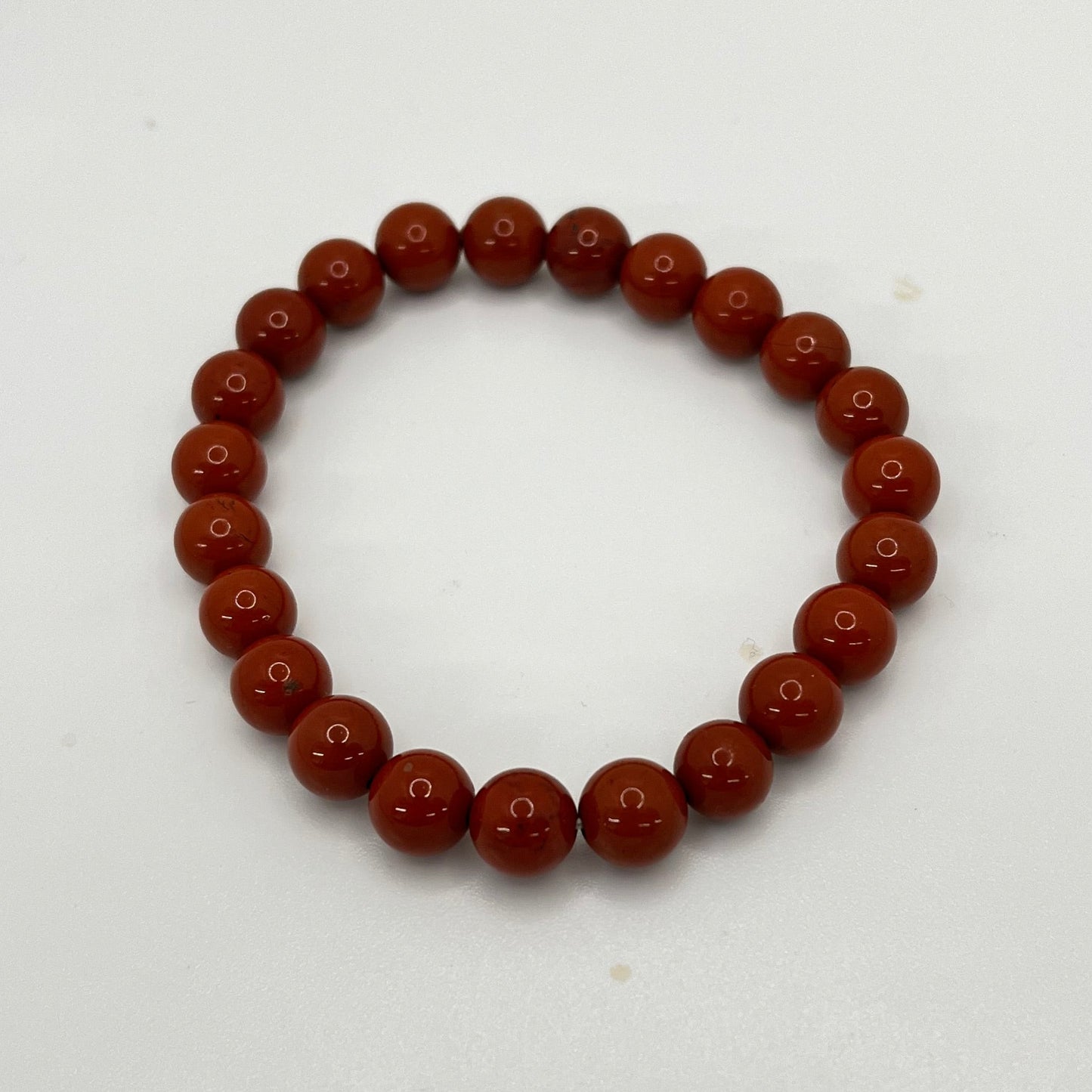 Rust colored beaded bracelet on a white background
