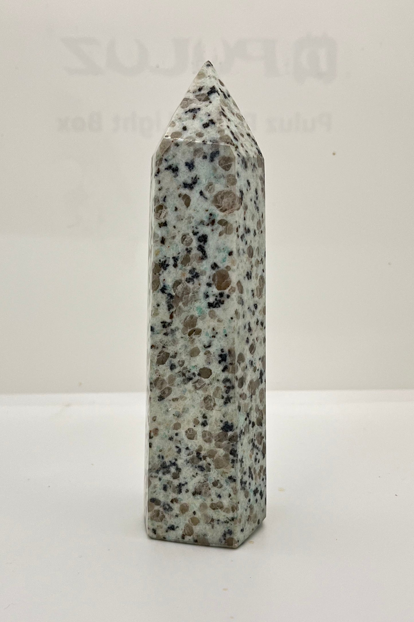 Gray obelisk with speckled pattern on a white background