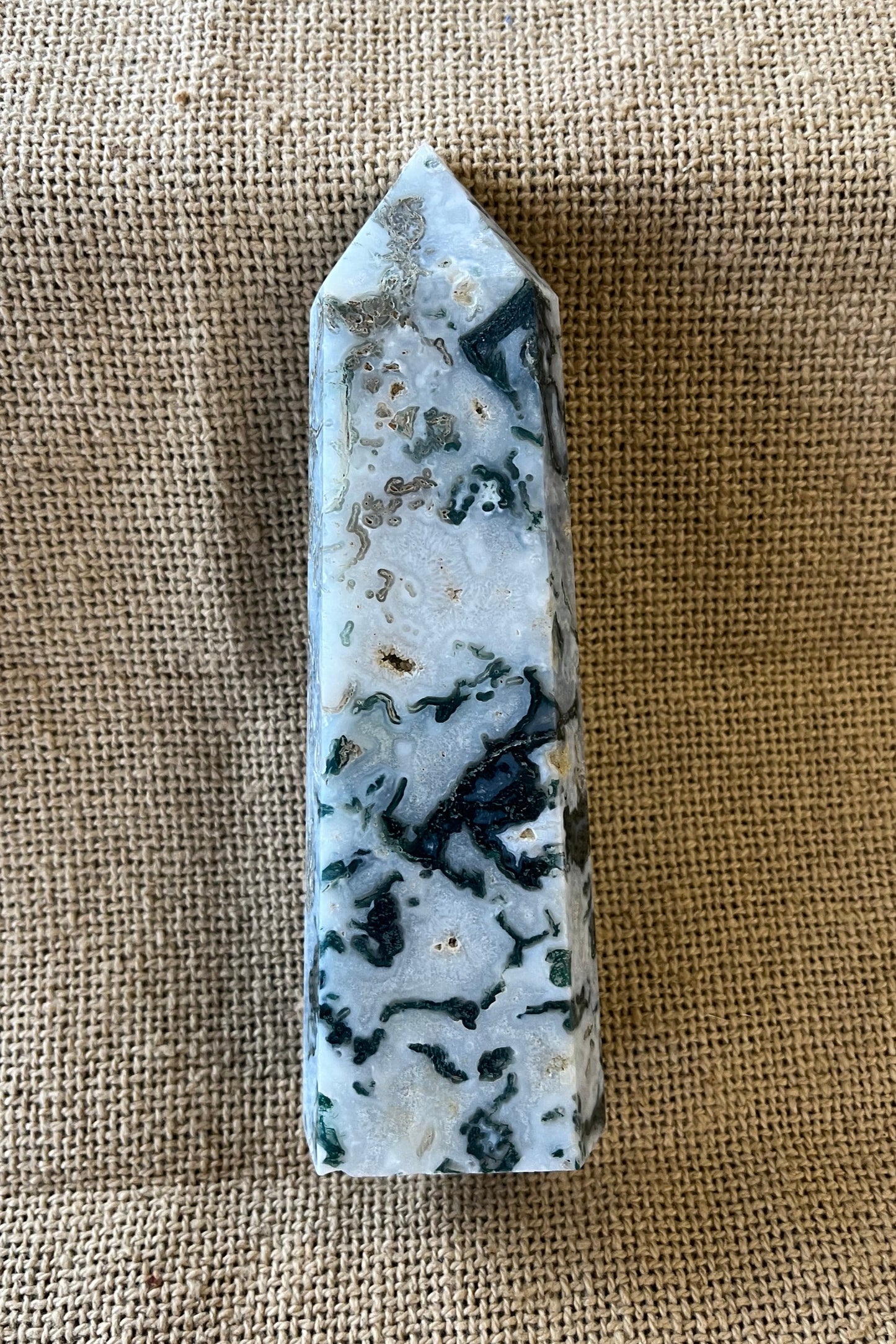 white and gray stone marbled with greens and blues, carved into the shape of a tower. It gives cool and natural vibes.