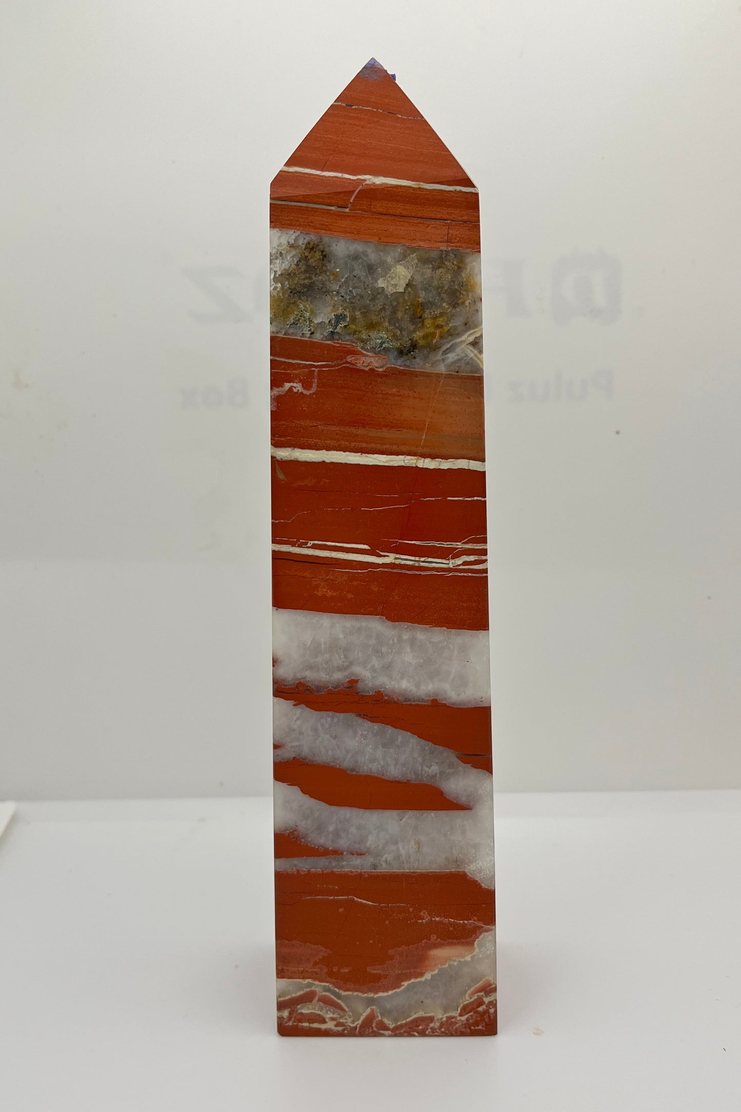 A red jasper tower with white crystal and white solid streaks, with a large streak of crystal with various inclusions.