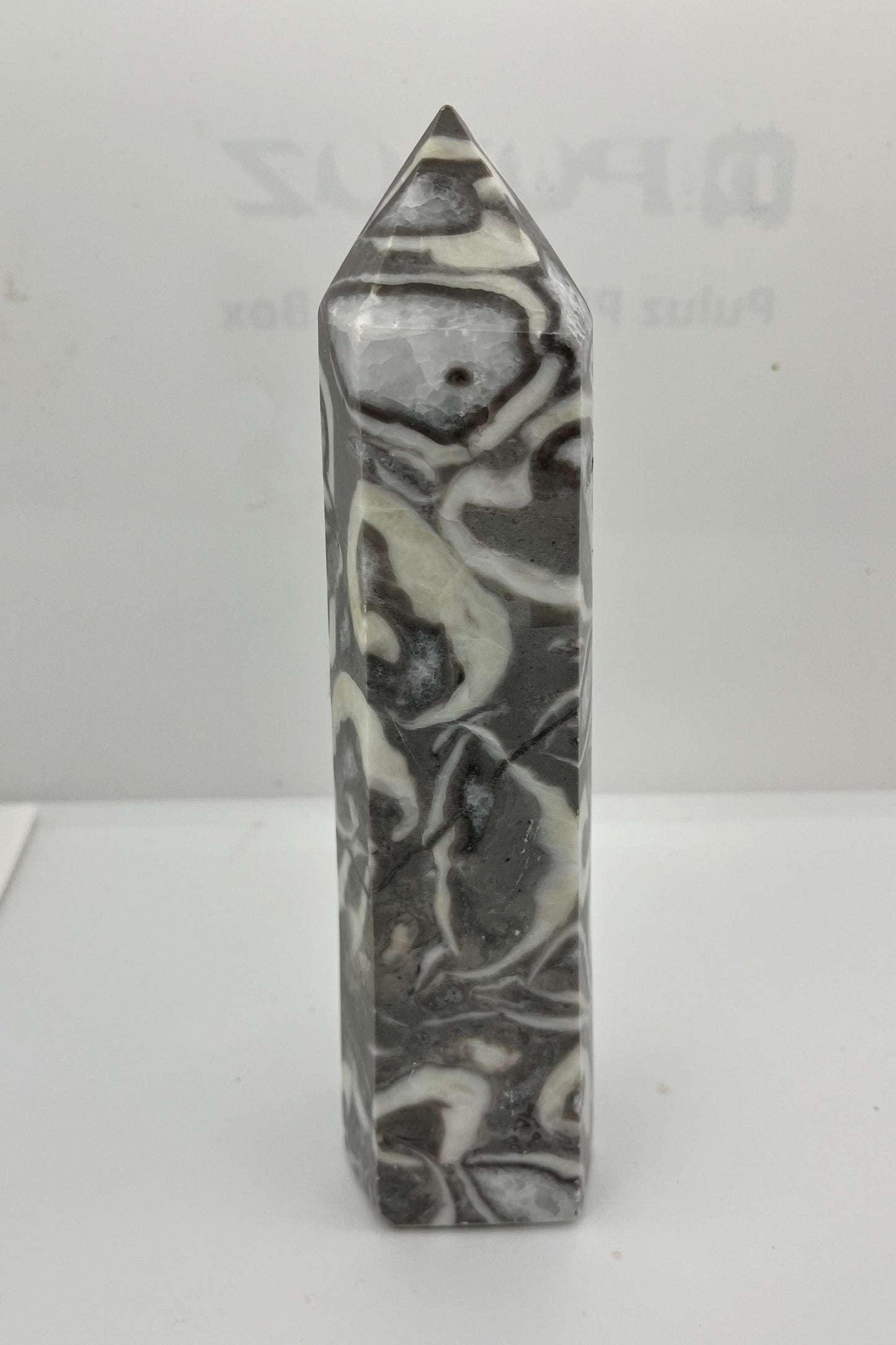 Marble gray white and black patterned crystal tower on a white background