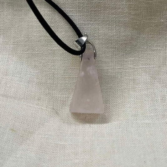 Necklace with a rose quartz pendant on a light fabric background