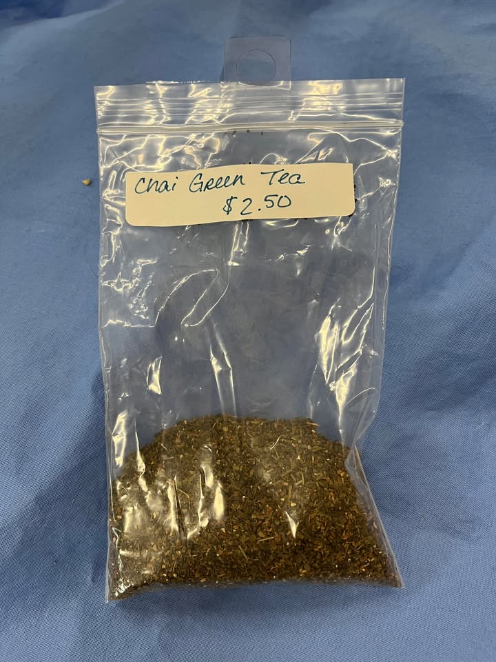 Finely ground brown leaves in a clear package labeled "Chai Green Tea, $2.50 per oz" 