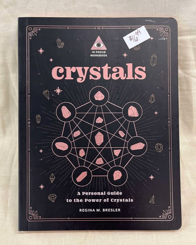 Book titled 'Crystals: A personal guide to the power of crystals' with pink text on a black cover, featuring a crystal grid. 
