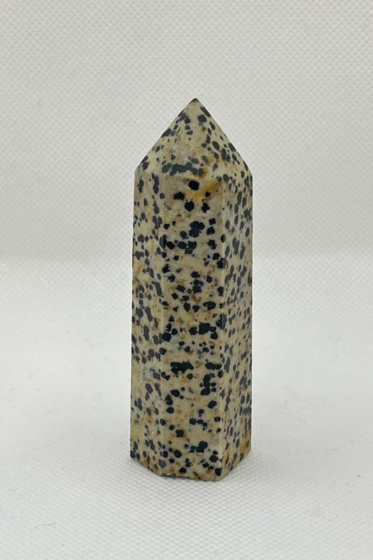Tan crystal tower with 6 sides, with black and brown specs throughout the stone.  