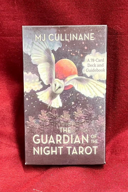 A boxed tarot deck titled "The Guardian of Night Tarot" by M.J. Cullinane, placed on a red fabric surface. The deck shows an owl flying over the trees in front of the sky filled with stars and a bright moon.