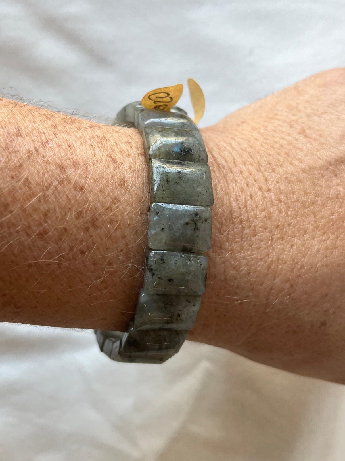 A bracelet of rectangles of semi-irridescent gray/lack stones. 