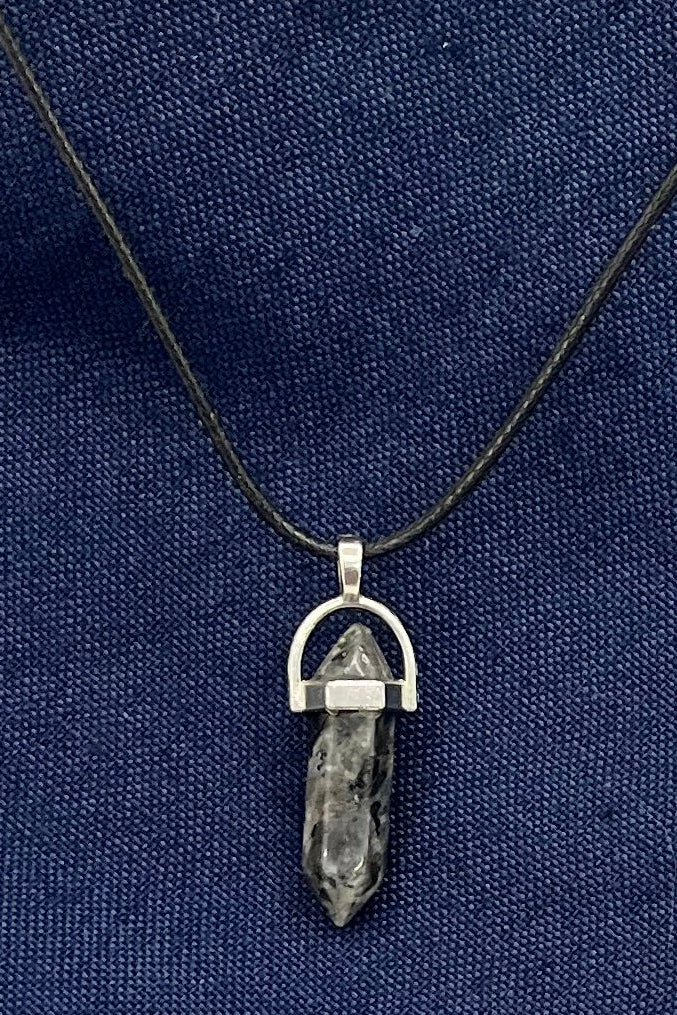 Gray and black marbled double-pointed stone in a silver finding on a black cord.
