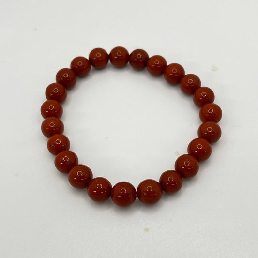 Rust colored beaded bracelet on a white background