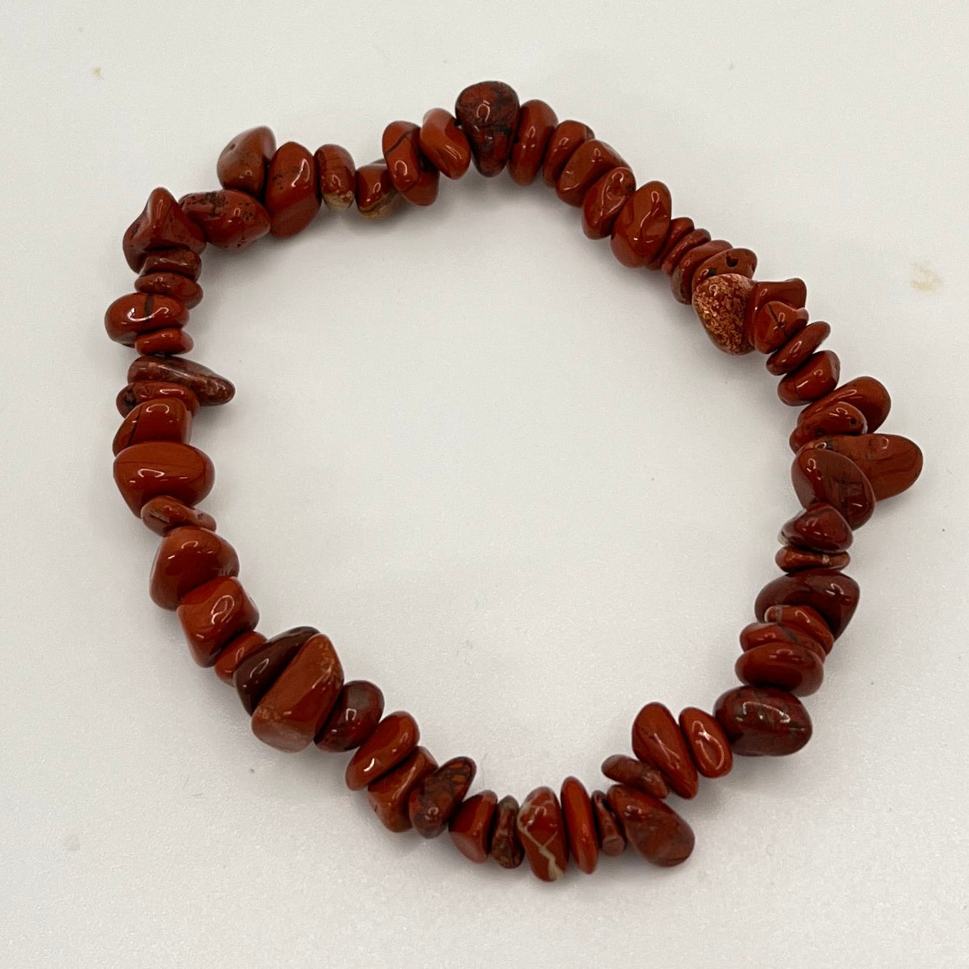 Bracelet of red beaded chips on a white background