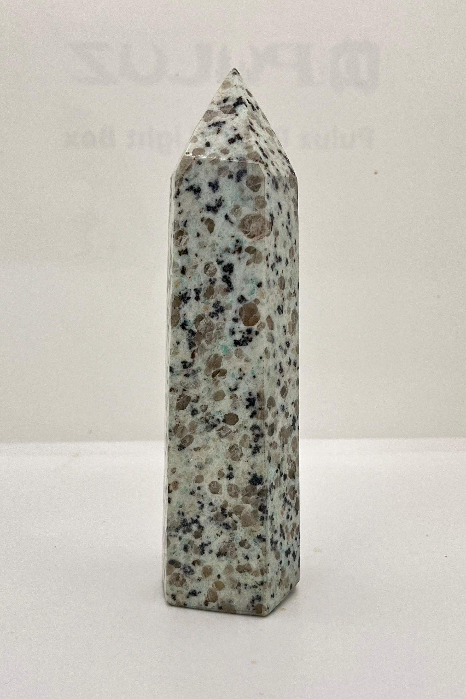 Gray obelisk with speckled pattern on a white background