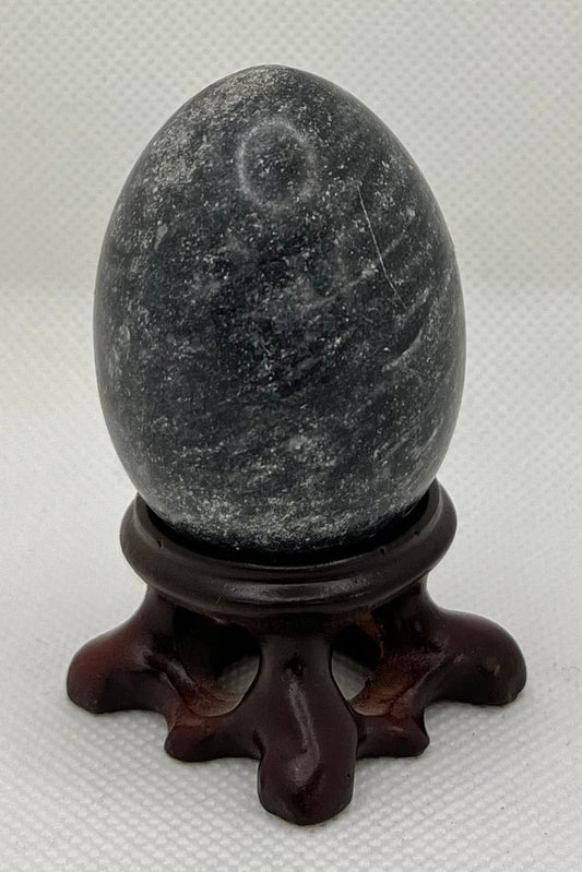 Decorative gray-blue egg on a stand on a white background