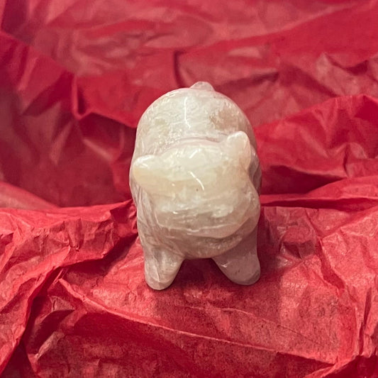 A small beige carved figurine of a pig