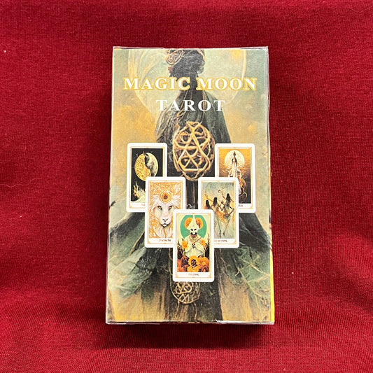 A boxed tarot card deck titled 'Magic Moon Tarot' standing upright on a red fabric surface. 