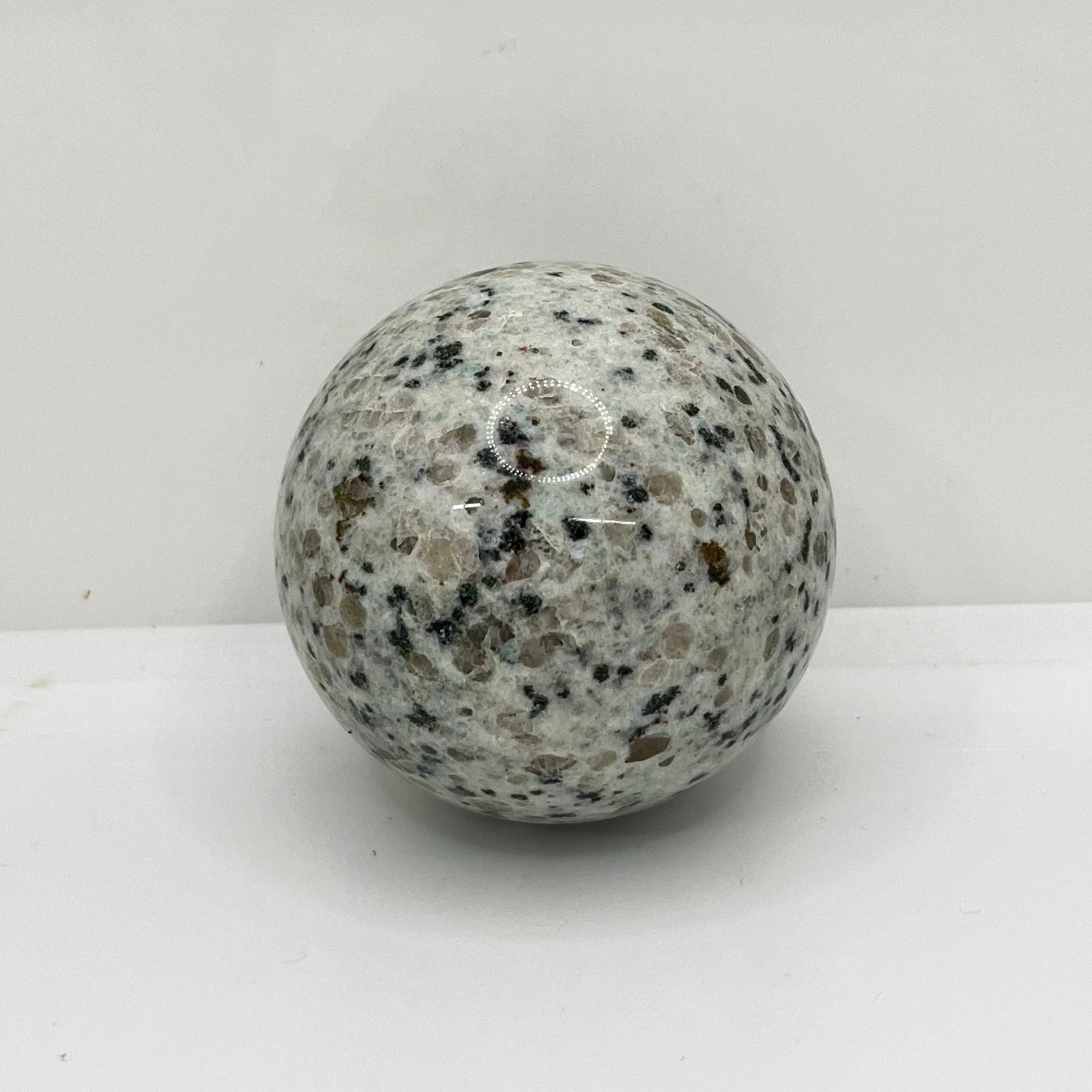 Speckled gray crystal on a white background.  