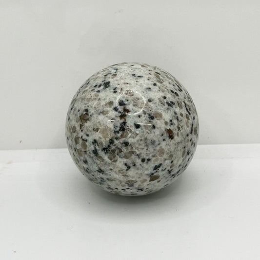 Speckled gray crystal on a white background.  