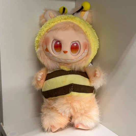 Plush toy dressed as a bee in a white shelf setting