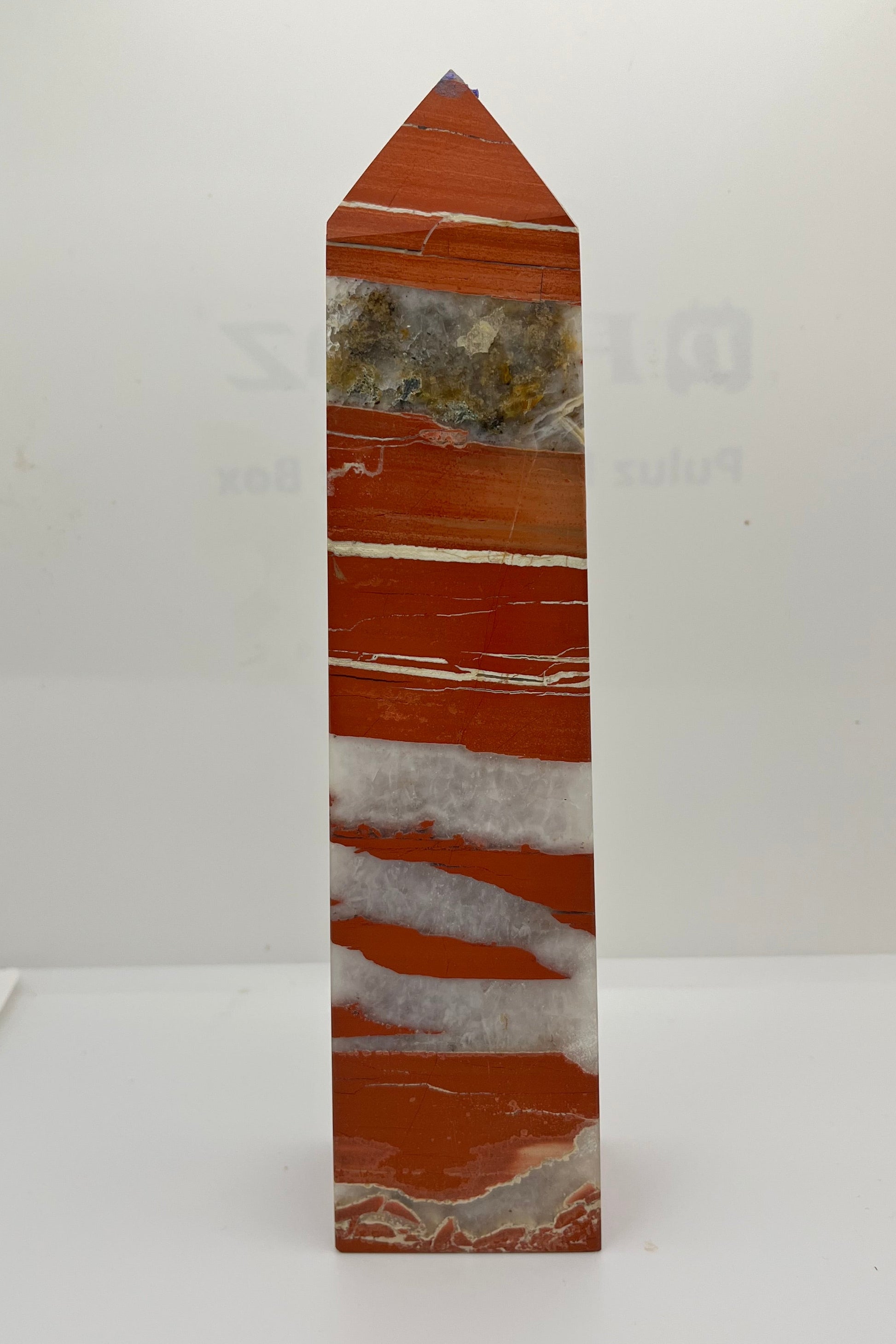 A red jasper tower with white crystal and white solid streaks, with a large streak of crystal with various inclusions. 