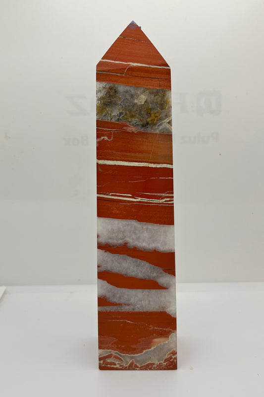 A red jasper tower with white crystal and white solid streaks, with a large streak of crystal with various inclusions. 