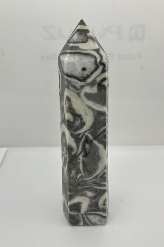 Marble gray white and black patterned crystal tower on a white background