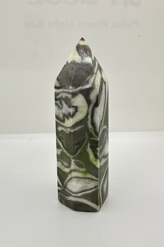 Marbled gray, white, and dark gray patterned crystal tower on a white background