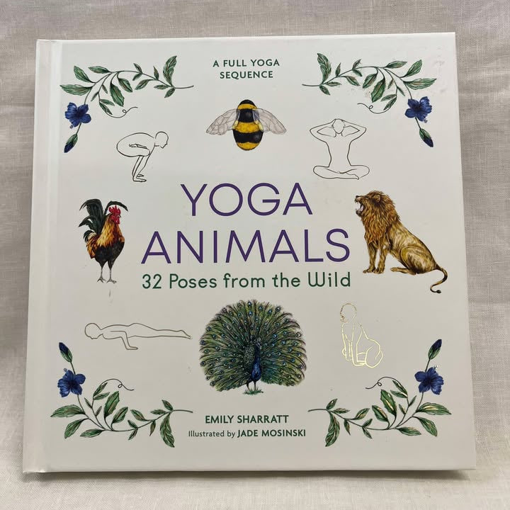 Book titled 'Yoga Animals: 32 Poses from the Wild' by Emily Sharratt on a light cream background, with a rooster, bee, lion, and peacock as well as 4 basic line drawings of people in yoga poses, as well as flowers on a leafy stem on each corner.